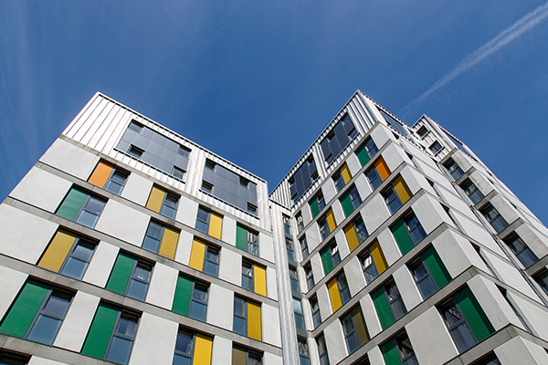 modern architecture of a building with colorful window panels under a clear blue sky featuring design elements that emphasize vertical lines and structure 9 stories high