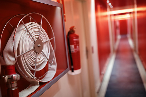 fire hose on wall in red hallway with fire extinguisher for safety management in high rise buildings 8 features