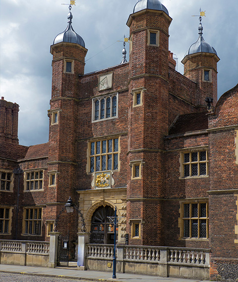 historical brick building with towers and ornate entrance featuring five architectural elements