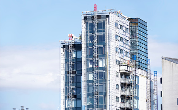 modern building under construction with scaffolding and blue sky showcasing architectural design and features of ten floors
