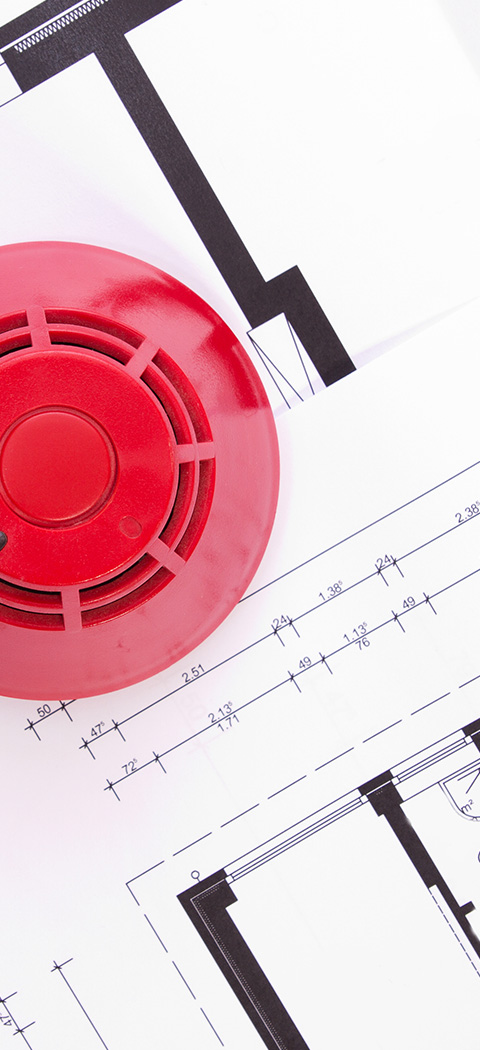 red smoke detector on architectural blueprints with safety designs ensuring nine key areas are monitored