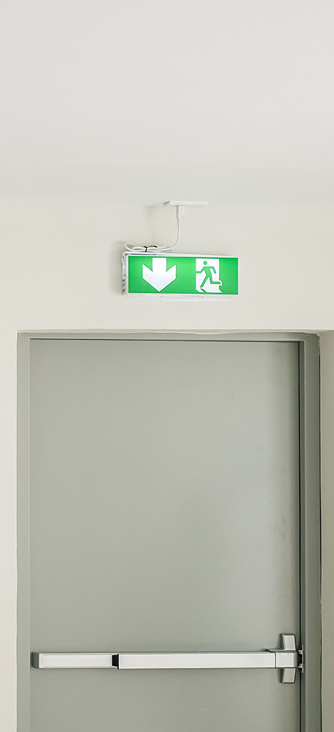 exit sign above a grey door indicating a safe exit route featuring a downward arrow and a figure walking towards safety this emergency exit sign is crucial for directions during an evacuation situation ensuring safety for all individuals including those pertaining to the number 13